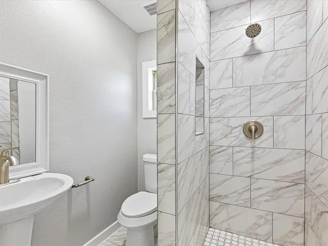 a bathroom with a sink toilet and shower