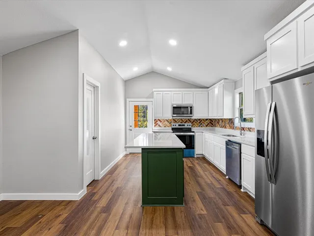 a kitchen with white cabinets and stainless steel appliances