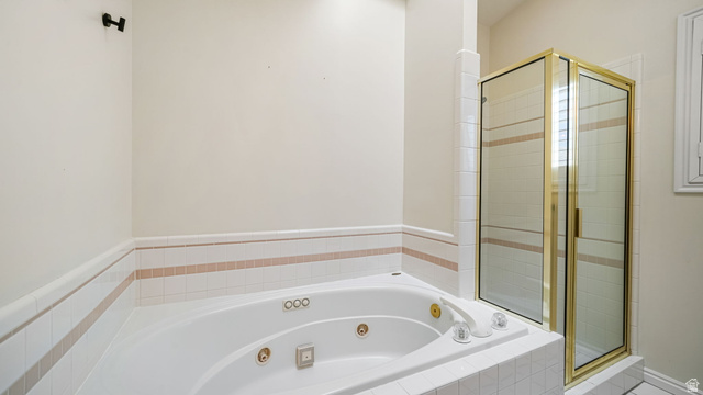 11128 South Barrett Pk Circle Sandy, UT 84092 - Photo 18 of 36 Jetted soaking tub with a tiled surround featuring accent banding