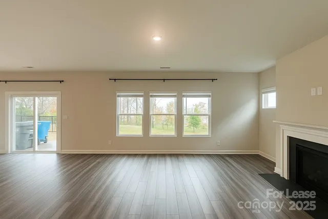 an empty room with wooden floor and fireplace