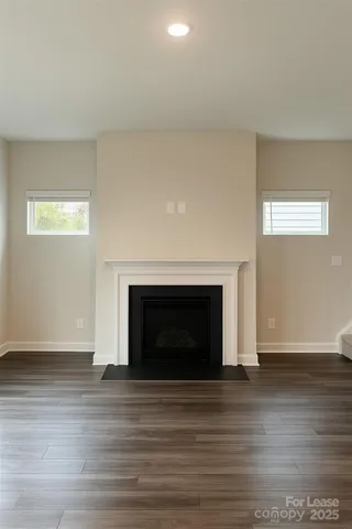 a view of empty room with wooden floor and fireplace