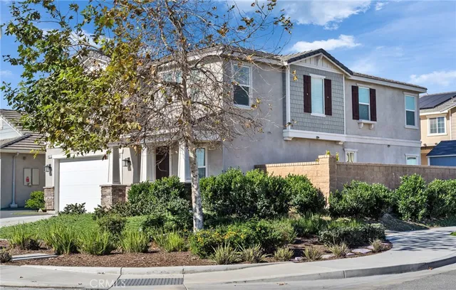 a front view of a house with plants and trees