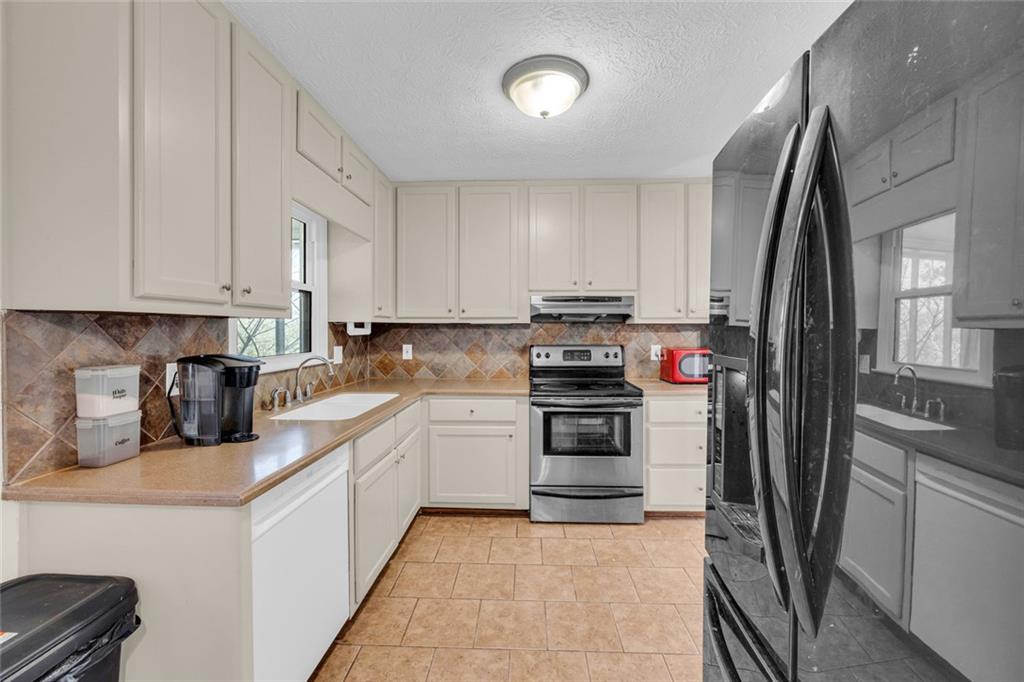 3765 Linwood Way Snellville, GA 30039 - Photo 20 of 53 a kitchen with stainless steel appliances granite countertop a refrigerator sink and stove