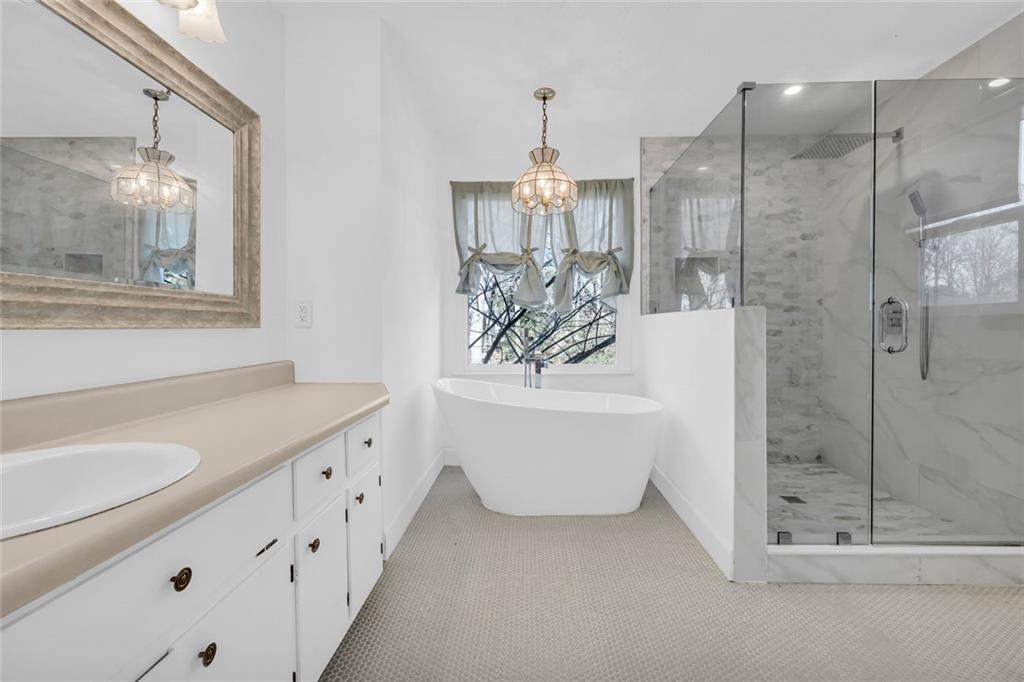 3765 Linwood Way Snellville, GA 30039 - Photo 27 of 53 a bathroom with a tub sink and mirror