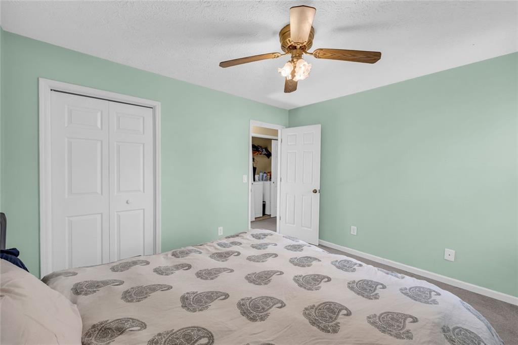 3765 Linwood Way Snellville, GA 30039 - Photo 32 of 53 a bedroom with a large bed and a chandelier