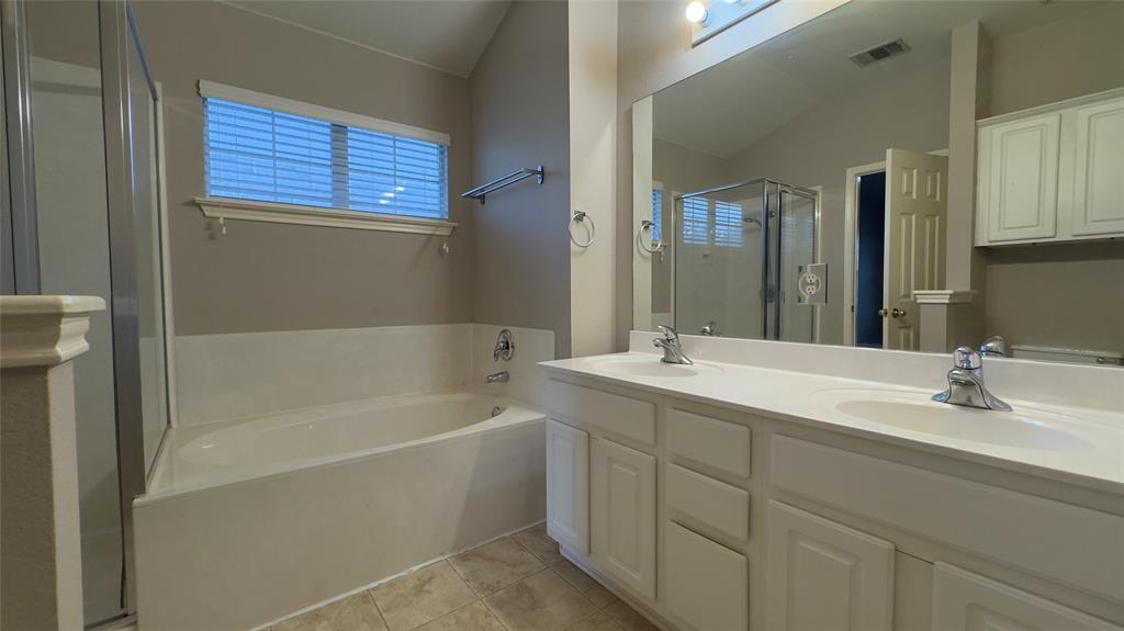 1900 Scofield Ridge Parkway, Unit 5501 Austin, TX 78727 - Photo 7 of 21 Luxurious primary bath features dual vanities and a relaxing soaking tub with an adjacent shower.