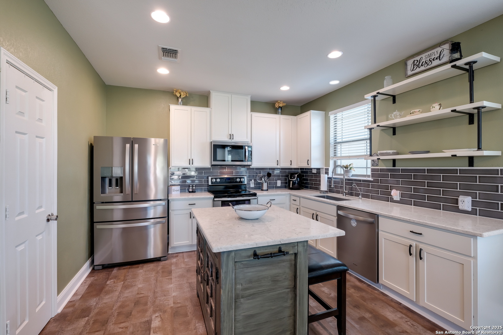 7207 Kitty Court Converse, TX 78109 - Photo 7 of 19 a kitchen with white cabinets stainless steel appliances and a center island