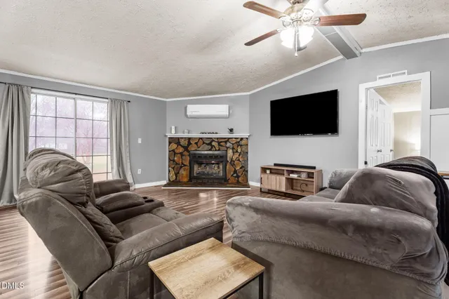 a living room with furniture a flat screen tv and a large window