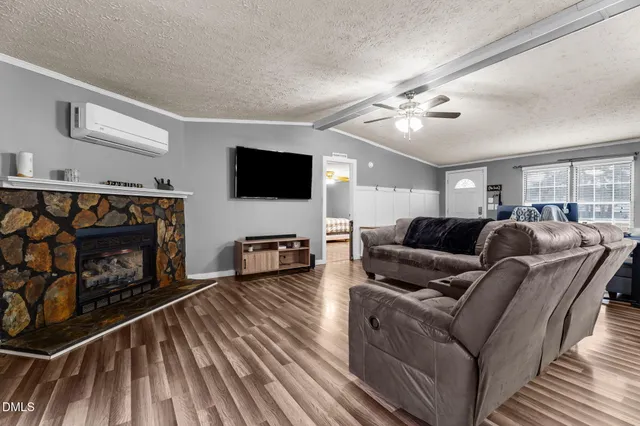 a living room with furniture a flat screen tv and a fireplace