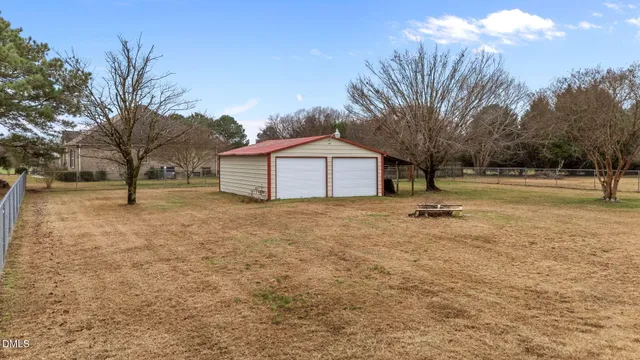 a view of house with backyard and tree