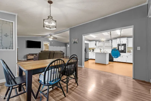a dining room with furniture a chandelier and wooden floor