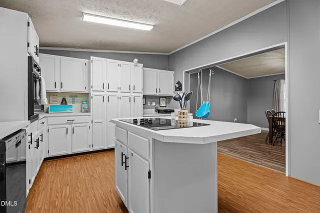 a kitchen with granite countertop a sink stove and cabinets