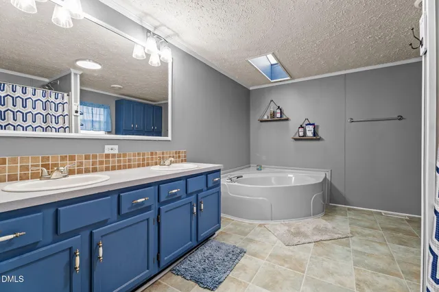a bathroom with a tub sink and mirror