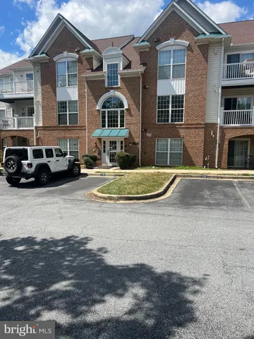 a front view of a residential apartment building with parking space