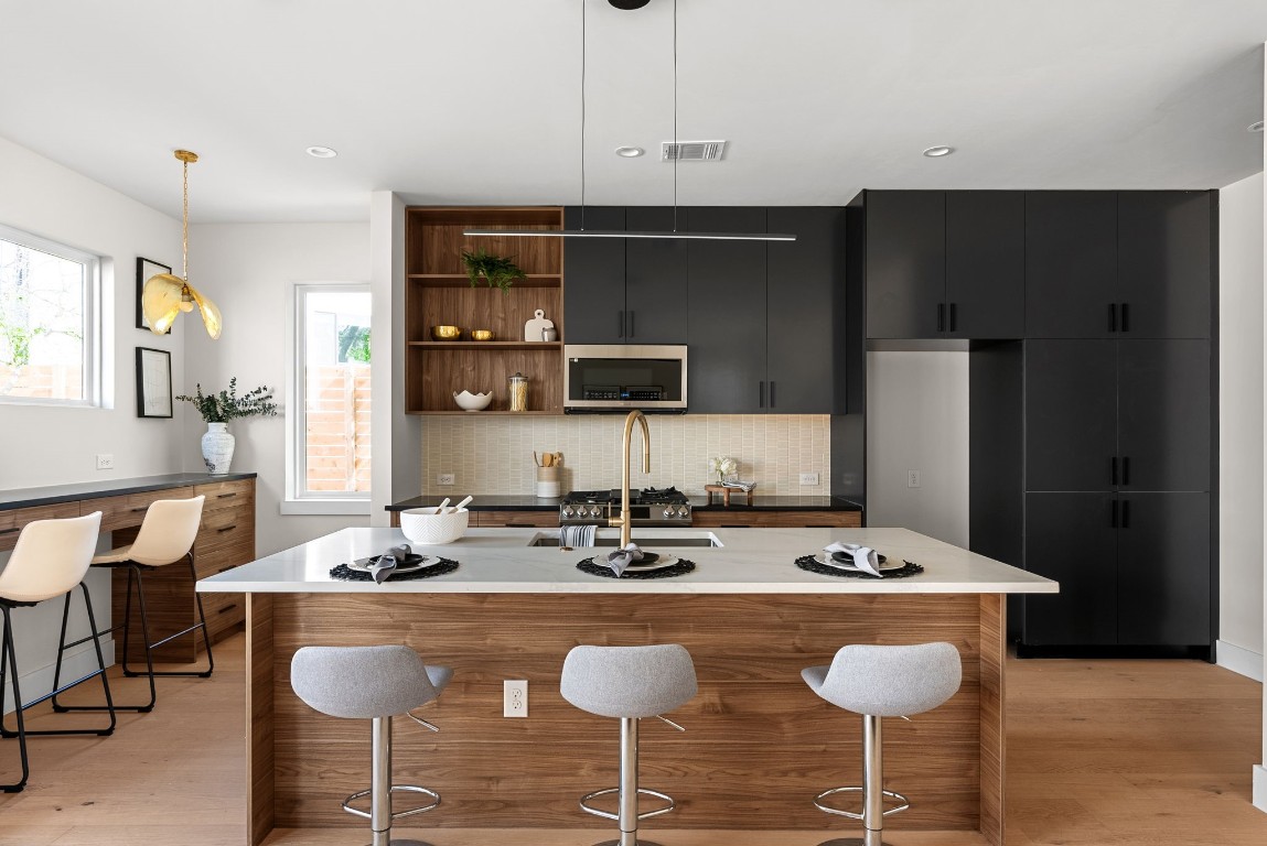 a kitchen with stainless steel appliances granite countertop a sink and a refrigerator