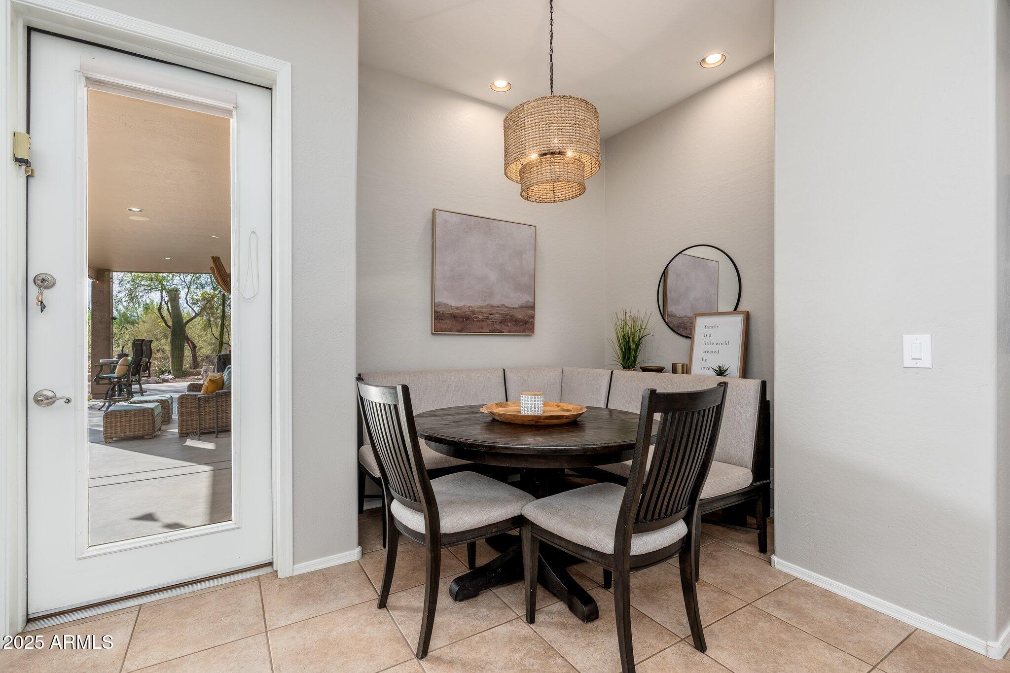 5712 East Blue Sky Drive Scottsdale, AZ 85266 - Photo 18 of 79 a dining room with wooden floor a glass table and chairs