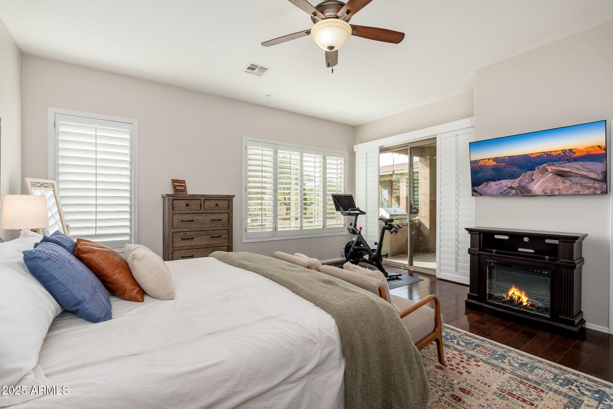 5712 East Blue Sky Drive Scottsdale, AZ 85266 - Photo 20 of 79 a bedroom with a bed a fireplace and a flat screen tv