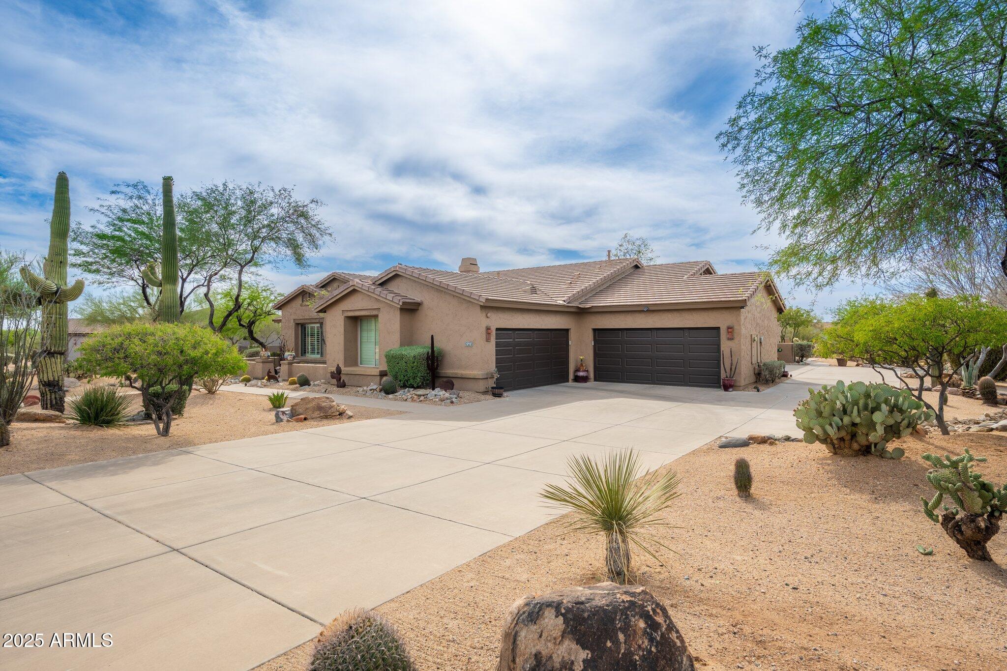5712 East Blue Sky Drive Scottsdale, AZ 85266 - Photo 2 of 79 a front view of a house with a garden and trees