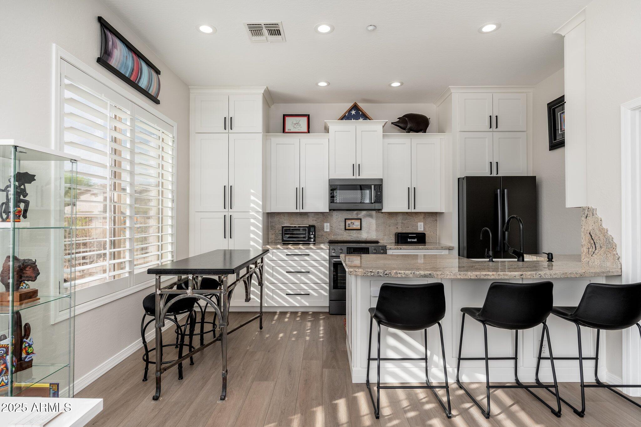 5712 East Blue Sky Drive Scottsdale, AZ 85266 - Photo 43 of 79 a kitchen with stainless steel appliances kitchen island granite countertop a dining table chairs and white cabinets