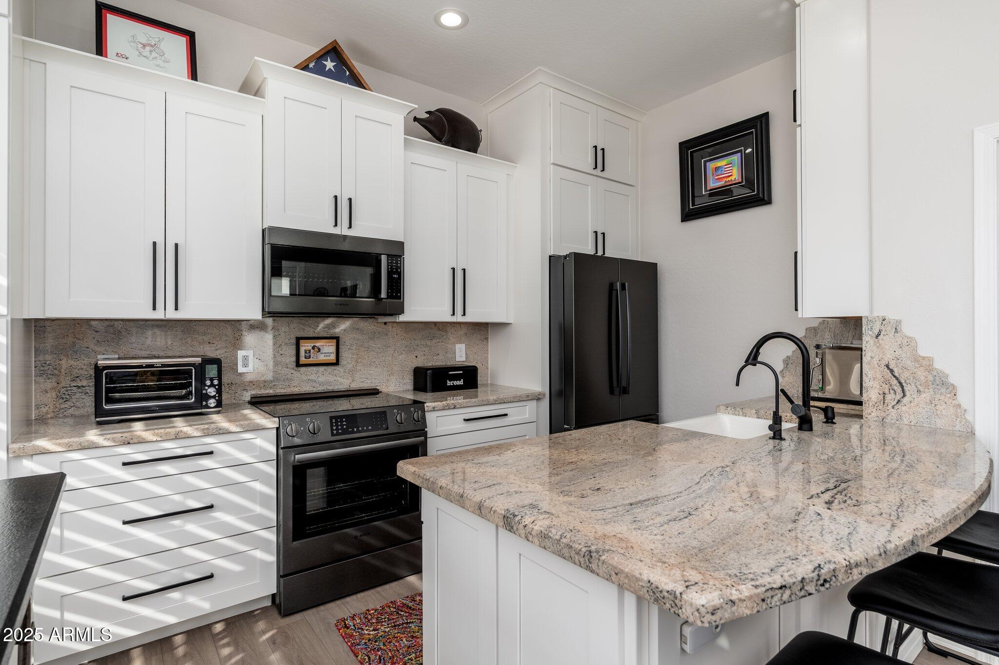 5712 East Blue Sky Drive Scottsdale, AZ 85266 - Photo 45 of 79 a kitchen with kitchen island a sink stove and microwave