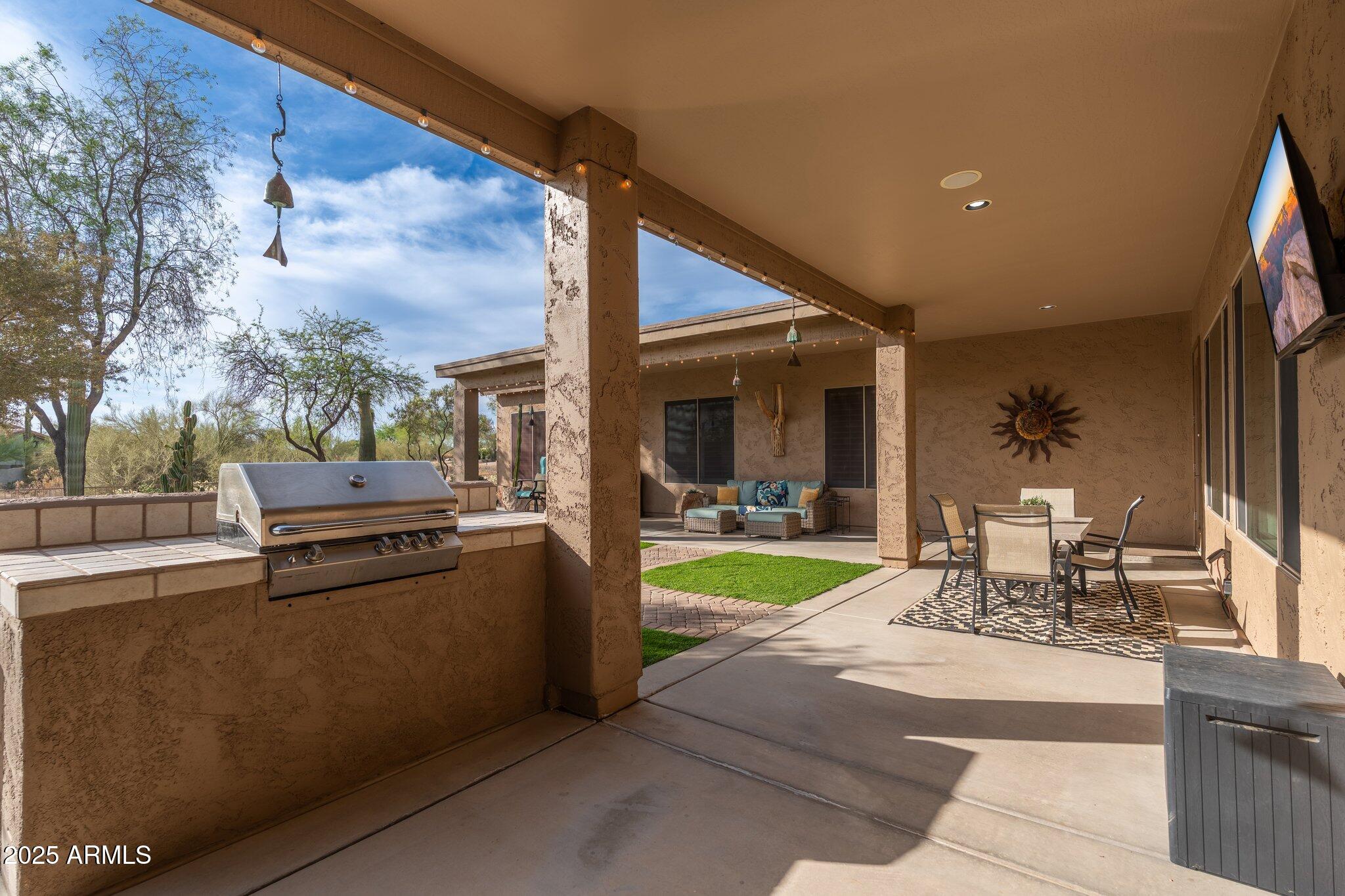 5712 East Blue Sky Drive Scottsdale, AZ 85266 - Photo 49 of 79 a view of a patio with a dining table and chairs with wooden floor