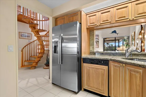 a kitchen with stainless steel appliances granite countertop a refrigerator and a sink