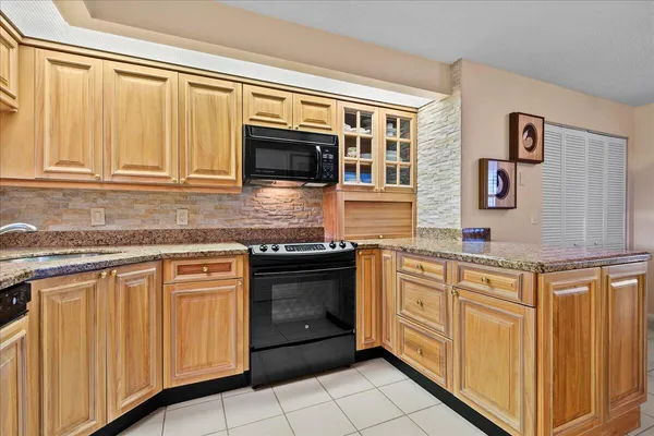 a kitchen with stainless steel appliances granite countertop white cabinets and sink