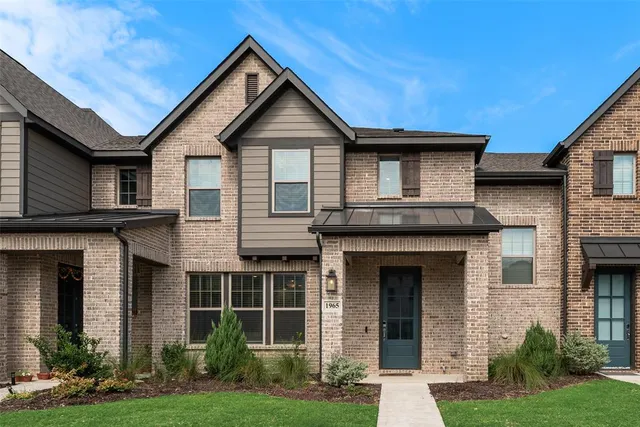 a front view of a house with a yard and green space