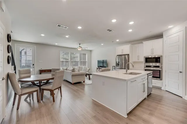 a living room with stainless steel appliances kitchen island granite countertop furniture and wooden floor