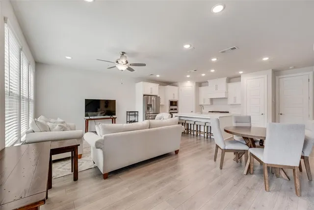 a living room with furniture kitchen view and a flat screen tv