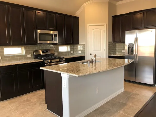 a kitchen with granite countertop a sink and a stove top oven
