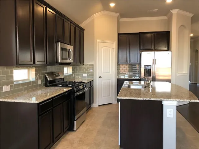 a kitchen with stainless steel appliances granite countertop a sink stove and refrigerator