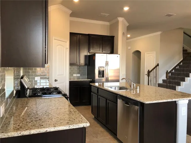 a kitchen with a sink and a stove top oven