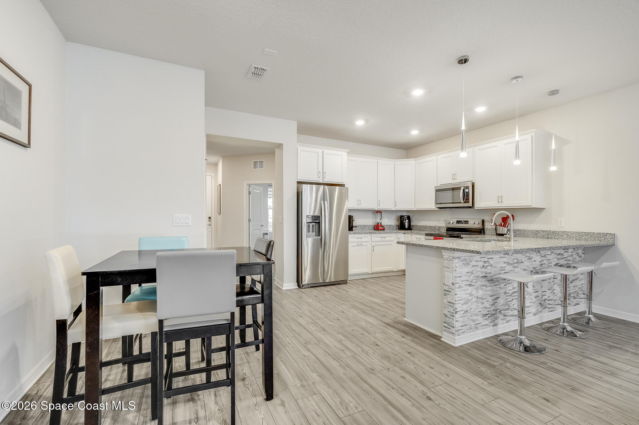 2202 Gopher Tortoise Terrace Oakland, FL 34787 - Photo 3 of 42 a living room with stainless steel appliances kitchen island granite countertop a dining table chairs and a refrigerator