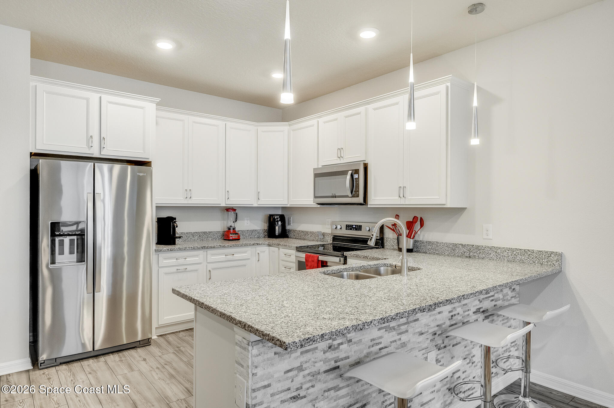2202 Gopher Tortoise Terrace Oakland, FL 34787 - Photo 4 of 42 a kitchen with stainless steel appliances granite countertop a refrigerator sink and white cabinets