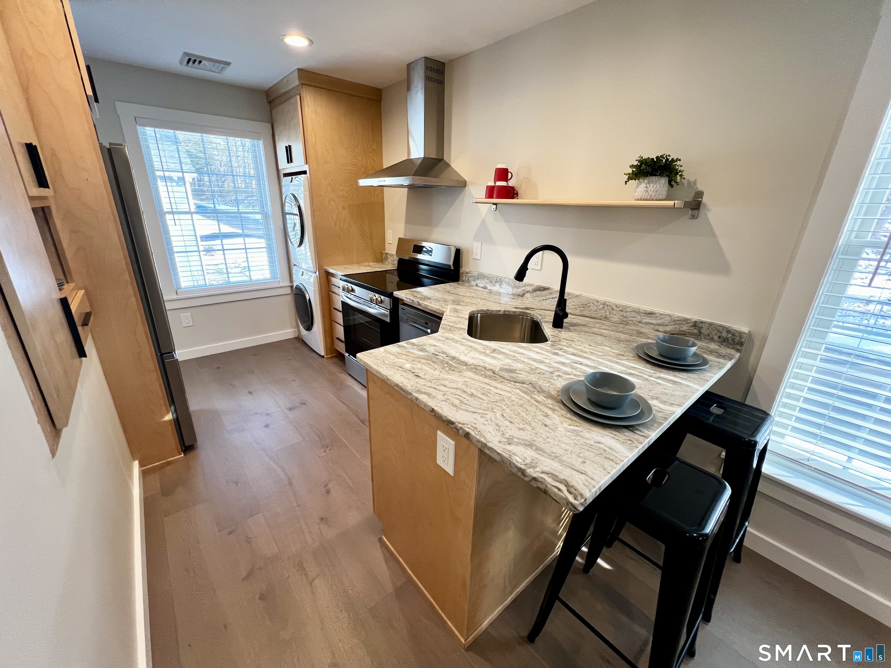 a view of kitchen island with sink and wooden floor