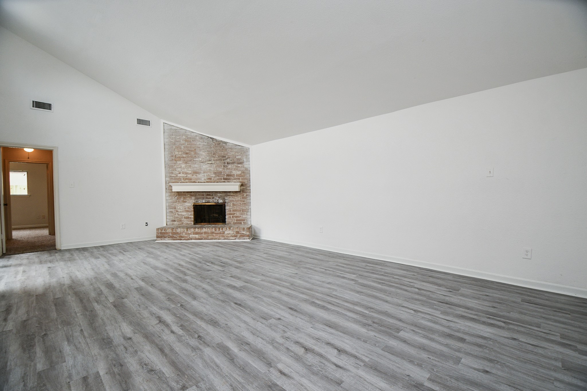 6411 Teal Run Drive Houston, TX 77035 - Photo 7 of 32 a view of an empty room with wooden floor fireplace and a window
