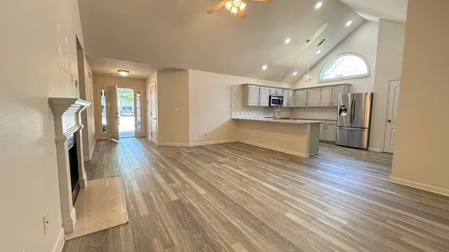 a kitchen with a sink dishwasher and white cabinets with wooden floor