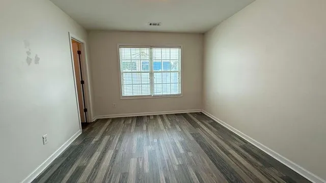 a view of a room with wooden floor and window