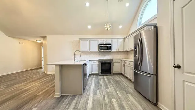 a kitchen with stainless steel appliances a refrigerator sink and microwave
