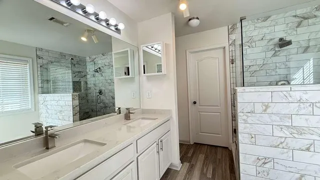 a spacious bathroom with a shower sink and mirror