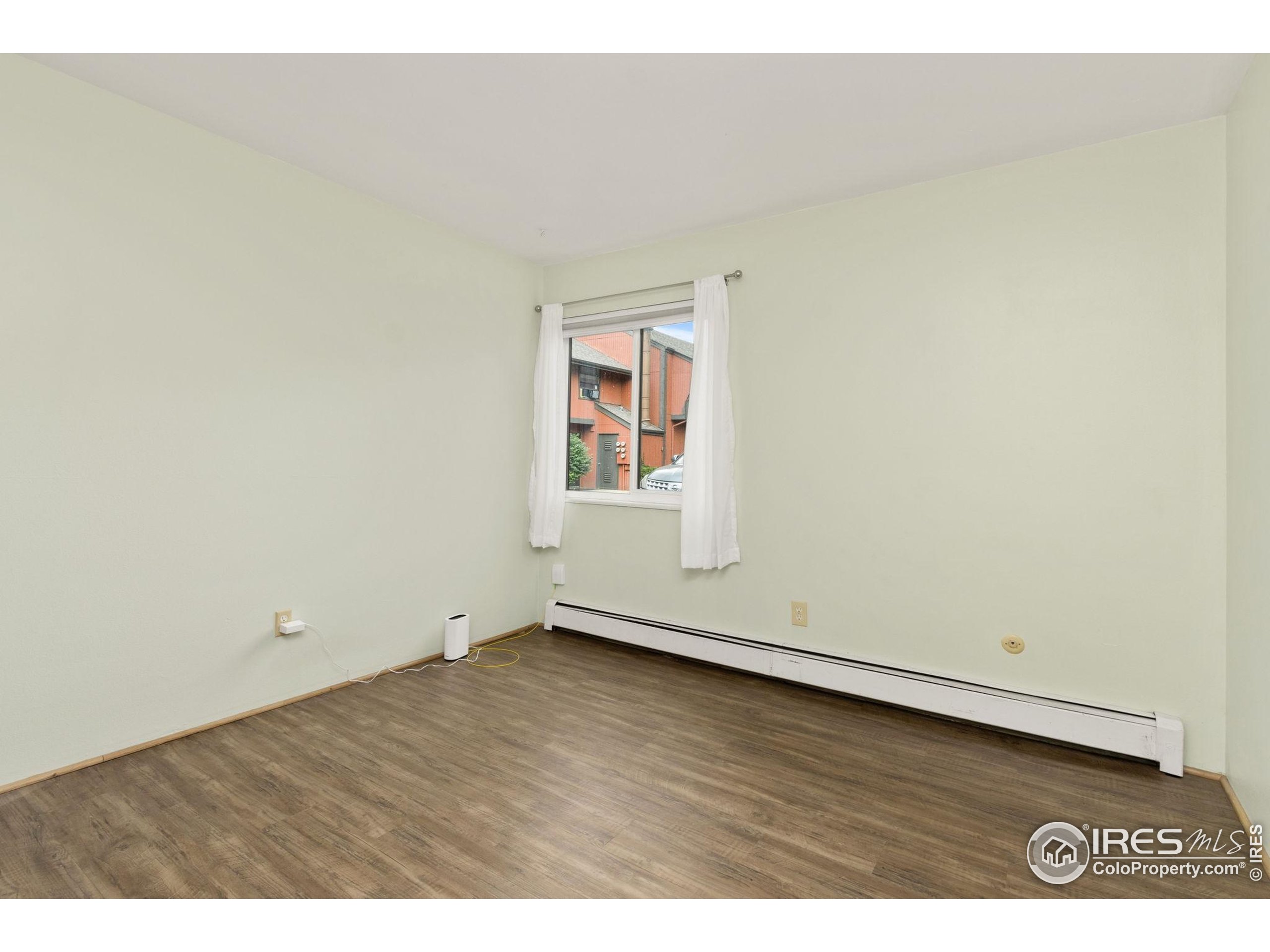 1625 West Elizabeth Street, Unit G2 Fort Collins, CO 80521 - Photo 24 of 45 an empty room with wooden floor and window