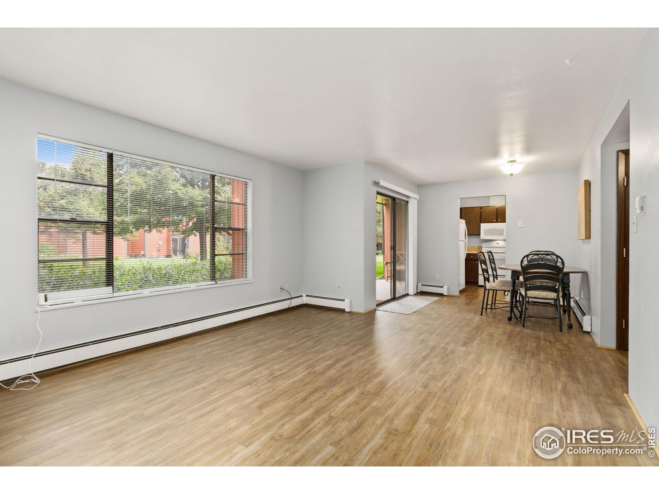 1625 West Elizabeth Street, Unit G2 Fort Collins, CO 80521 - Photo 7 of 45 a view of an empty room with a window and wooden floor