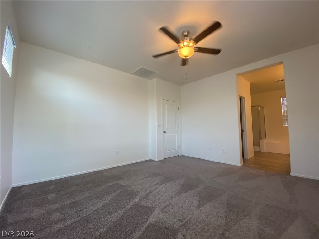 436 Cadence View Way Henderson, NV 89011 - Photo 19 of 36 Comfortable carpet and a ceiling fan create a relaxing atmosphere in this primary bedroom suite.