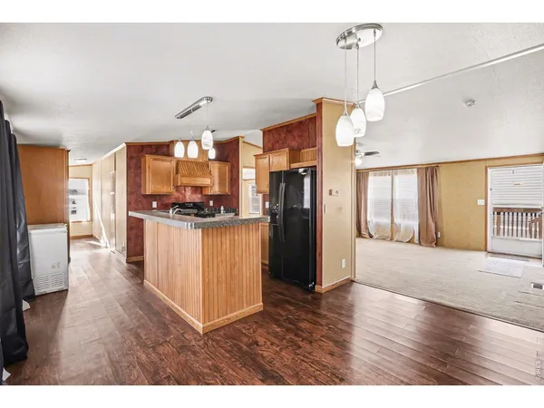 a kitchen with stainless steel appliances granite countertop a refrigerator a sink dishwasher with a dining table and chair
