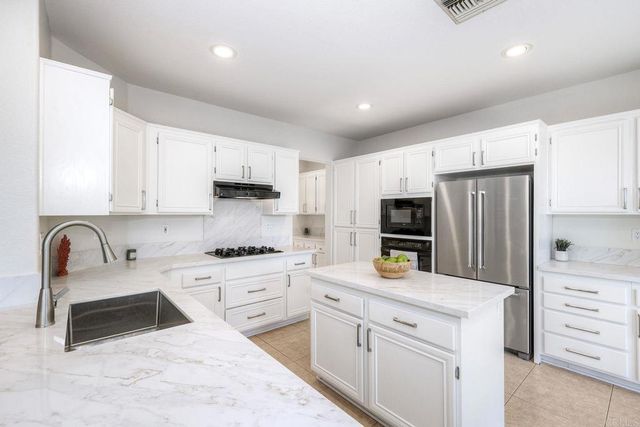 a kitchen with white cabinets and appliances