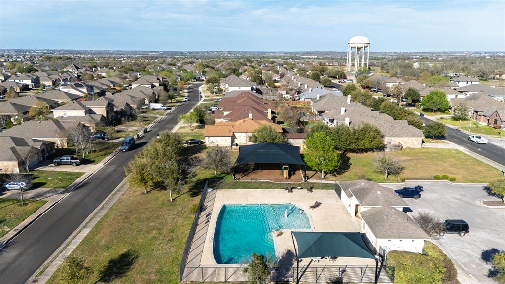 464 Evening Star Kyle, TX 78640 - Photo 8 of 8 An aerial perspective reveals a vibrant community pool with surrounding homes, offering a refreshing retreat.