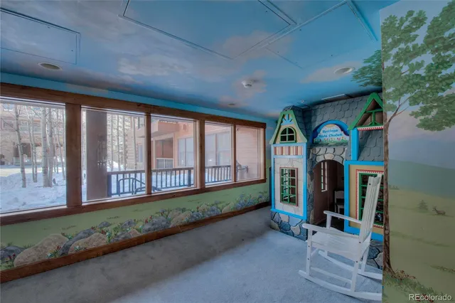 a living room with large windows and a large tree