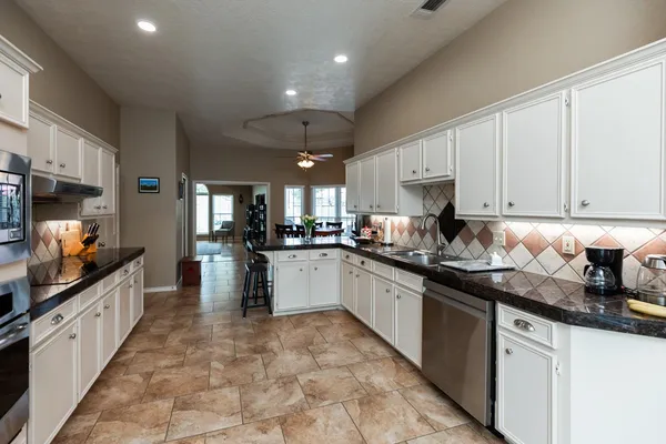 a kitchen with stainless steel appliances granite countertop a sink and cabinets