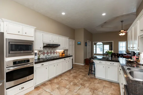a kitchen with granite countertop a stove sink and cabinets